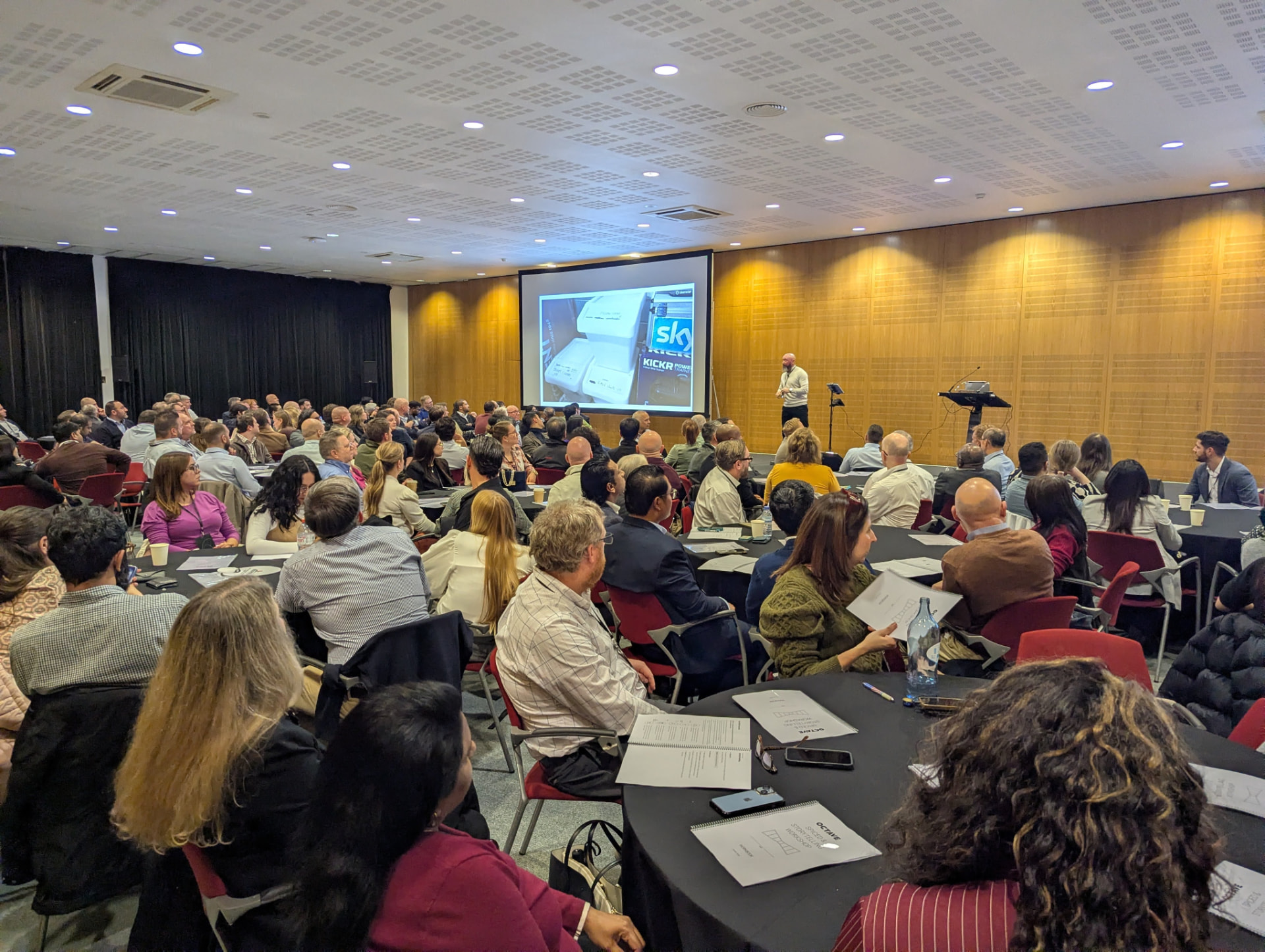 Shane McGrath presenting to a large seated audience